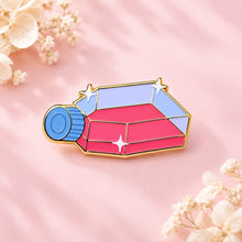 A colorful cell culture flask enamel pin against a blush-pink background with ivory dried flowers.