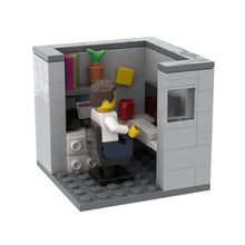 LEGO model of a person working at a desk in a cubicle